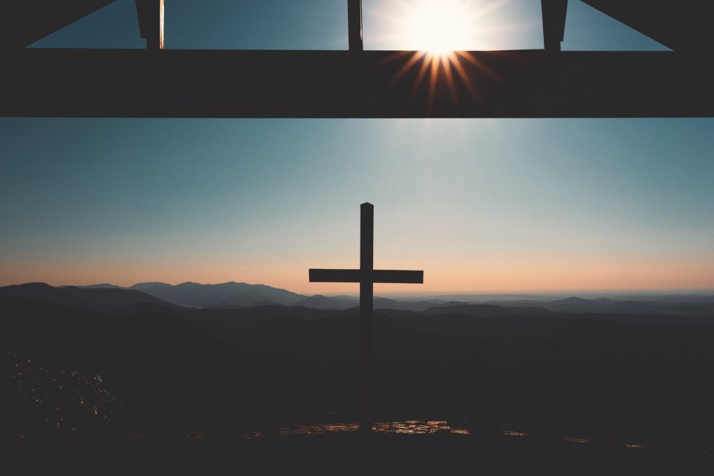 Christian cross at Pretty Place Chapel, overlooking the mountains with a scenic backdrop.