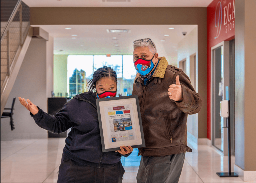 Photo of student working holding the firdst Dega Dispatch Newspaper with Luis Camillo at Talladega College. 