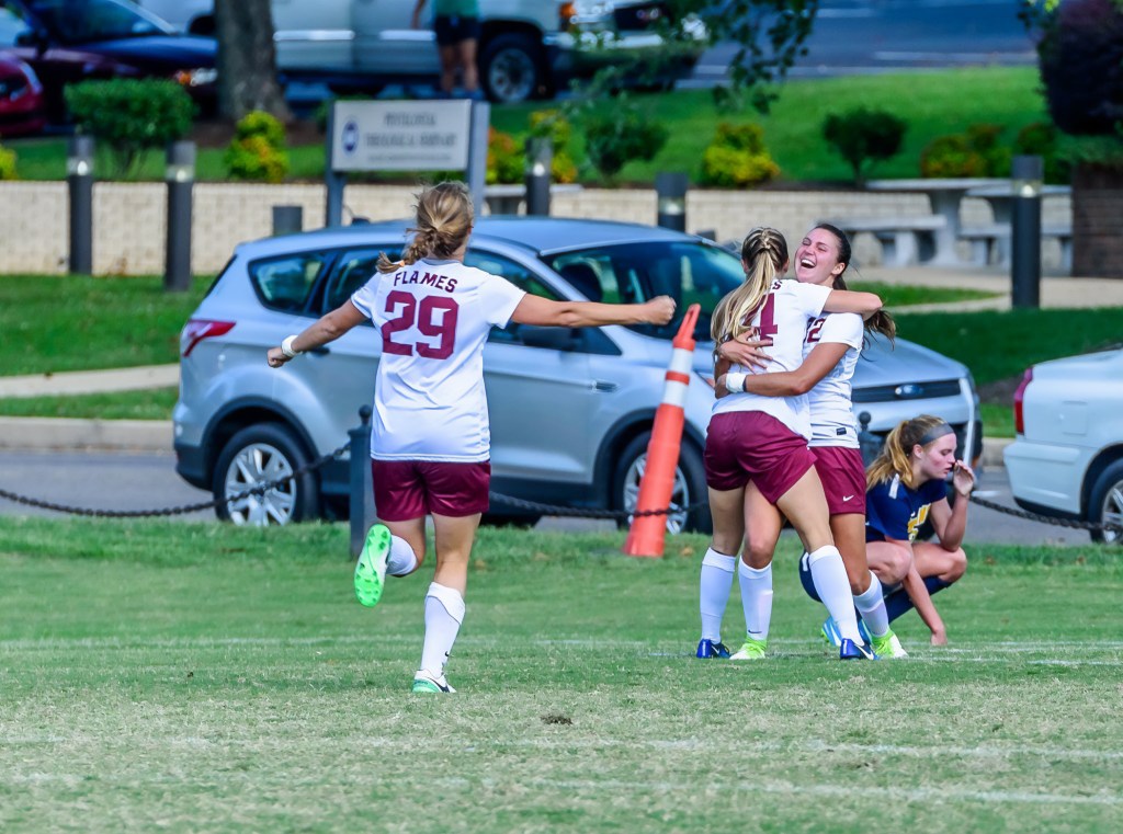 Soccer students celebrating together after a match, cheering and showing team spirit on the field.